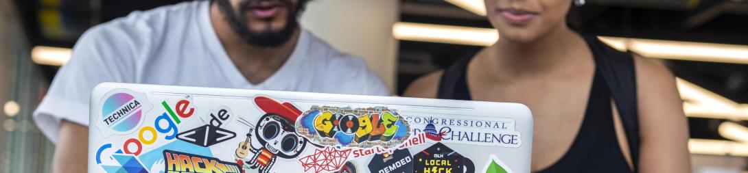 Two people looking at a laptop screen